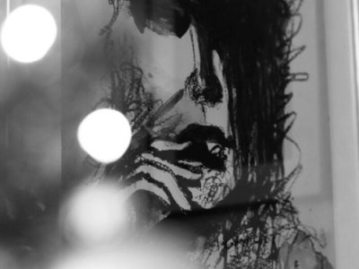 A black and white abstract portrait with artistic brushstrokes and bokeh lights.